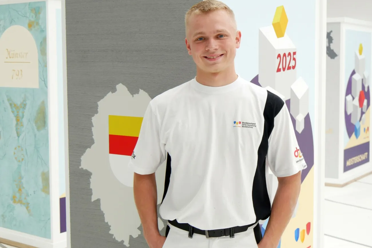 Maler und Lackierer Jonas Schneegans in weiß gekleidet posiert fürs Foto.